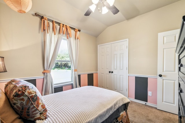 bedroom with carpet flooring, ceiling fan, a closet, and vaulted ceiling