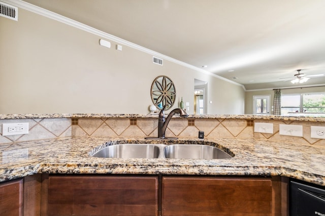 kitchen with ceiling fan, stone countertops, ornamental molding, and sink