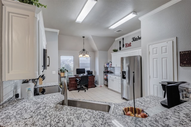 kitchen with white cabinets, lofted ceiling, an inviting chandelier, sink, and stainless steel fridge with ice dispenser