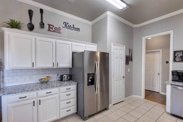 kitchen featuring light stone counters, white cabinets, light tile patterned floors, ornamental molding, and appliances with stainless steel finishes