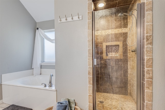 bathroom with shower with separate bathtub and vaulted ceiling