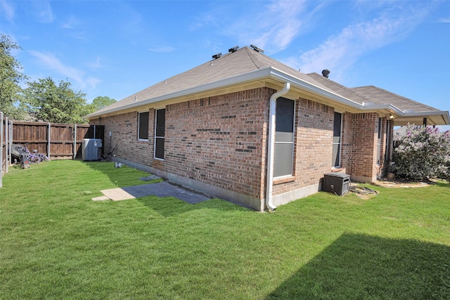 rear view of property with cooling unit and a lawn