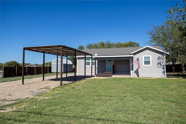 view of front of house featuring a front lawn and a shed