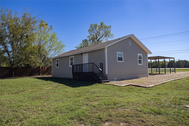 rear view of property featuring a wooden deck and a lawn