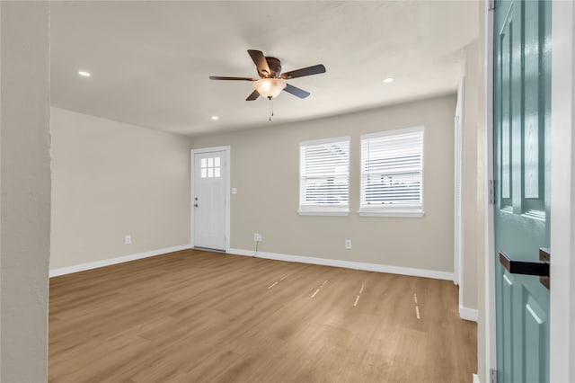 empty room with ceiling fan and light hardwood / wood-style floors