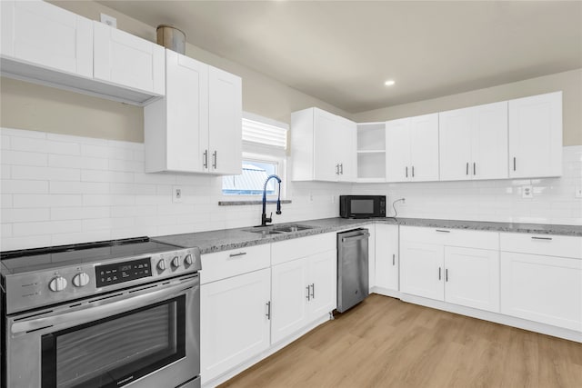 kitchen featuring light stone countertops, stainless steel appliances, white cabinetry, and light wood-type flooring