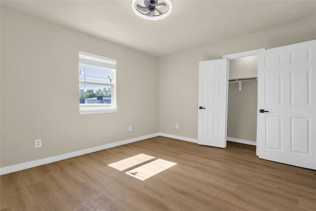 unfurnished bedroom featuring a closet and hardwood / wood-style flooring