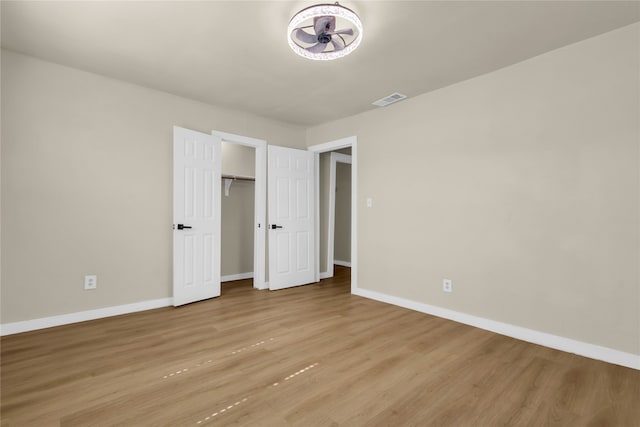 unfurnished bedroom with light hardwood / wood-style flooring and a closet