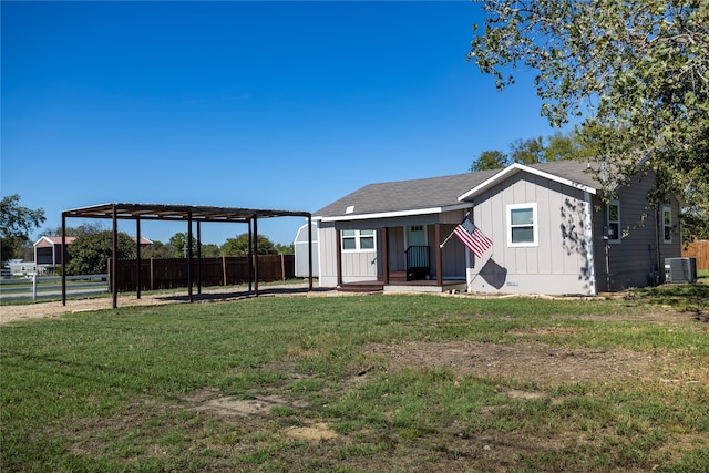 rear view of house featuring a lawn and central AC unit