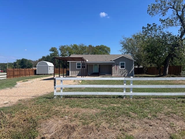 view of front facade with a storage shed and a front lawn