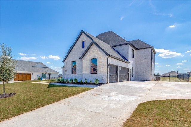 french country style house with a garage and a front lawn