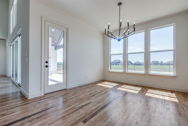 1120 Stonebridge Pass, Gunter, TX 75058 - unfurnished dining area featuring a chandelier, ornamental molding, healthy amount of natural light, and wood finished floors