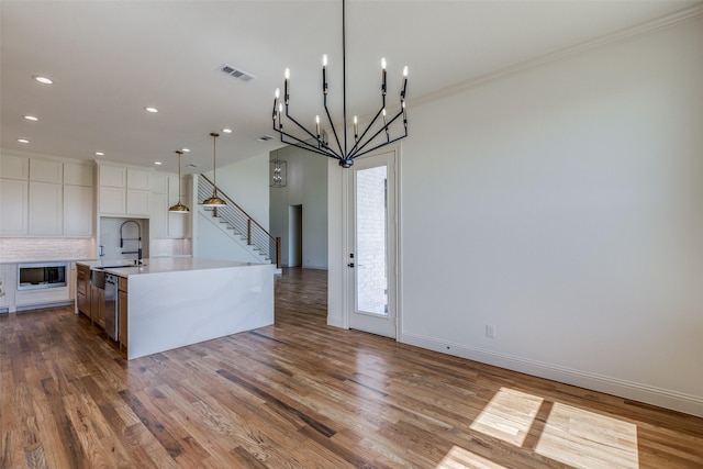 1120 Stonebridge Pass, Gunter, TX 75058 - kitchen featuring light countertops, wood finished floors, tasteful backsplash, built in microwave, and a large island with sink