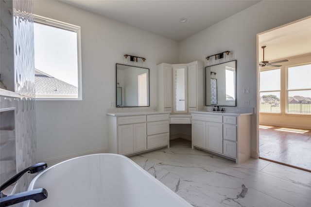 1120 Stonebridge Pass, Gunter, TX 75058 - bathroom featuring marble look tiles, a freestanding tub, vanity, and a ceiling fan