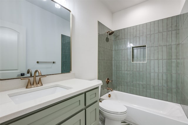 full bathroom featuring tiled shower / bath, vanity, and toilet