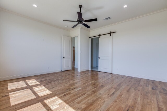 1120 Stonebridge Pass, Gunter, TX 75058 - unfurnished bedroom with light wood finished floors, baseboards, crown molding, a barn door, and recessed lighting