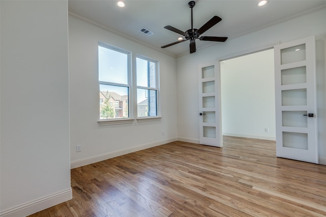 spare room featuring light hardwood / wood-style flooring, ceiling fan, and ornamental molding