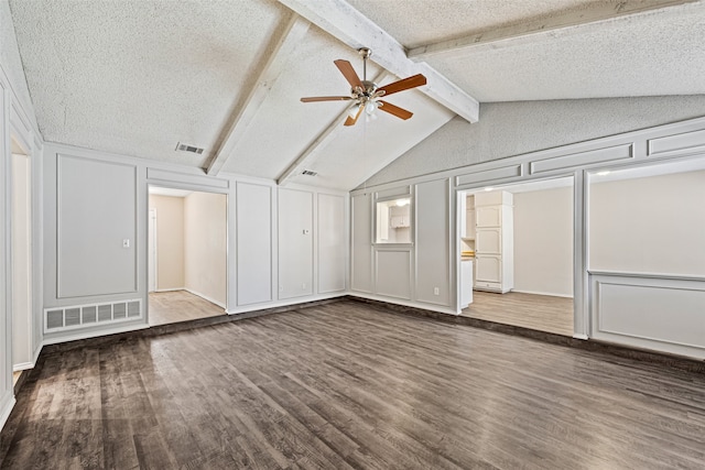 unfurnished living room featuring vaulted ceiling with beams, a textured ceiling, dark wood-type flooring, and ceiling fan