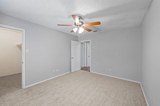 carpeted empty room with a textured ceiling and ceiling fan