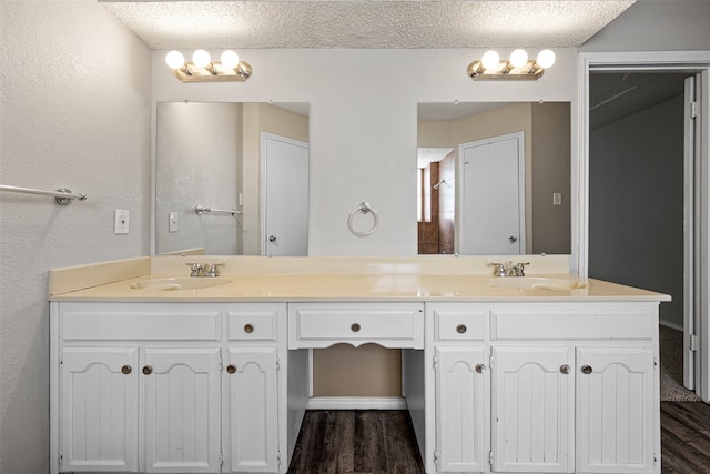 bathroom featuring vanity, hardwood / wood-style floors, and a textured ceiling