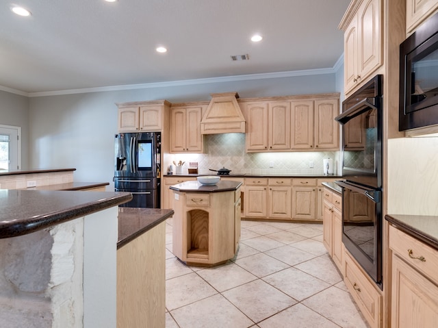 kitchen with black appliances, light brown cabinetry, and a center island