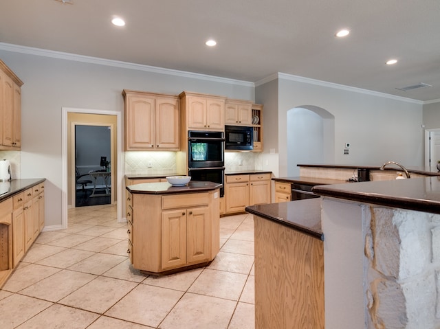 kitchen featuring black appliances, a center island, and light brown cabinets