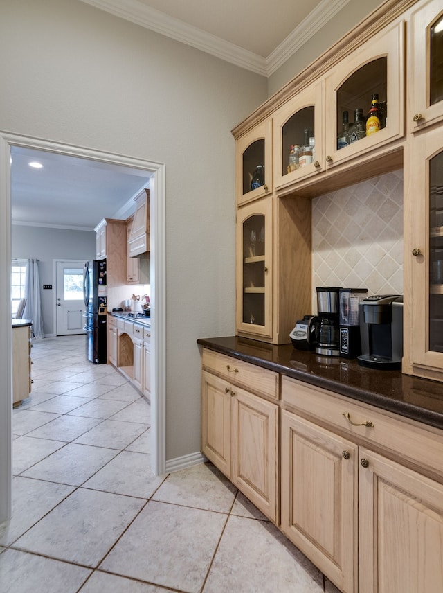 bar featuring backsplash, light tile patterned floors, crown molding, black refrigerator, and premium range hood