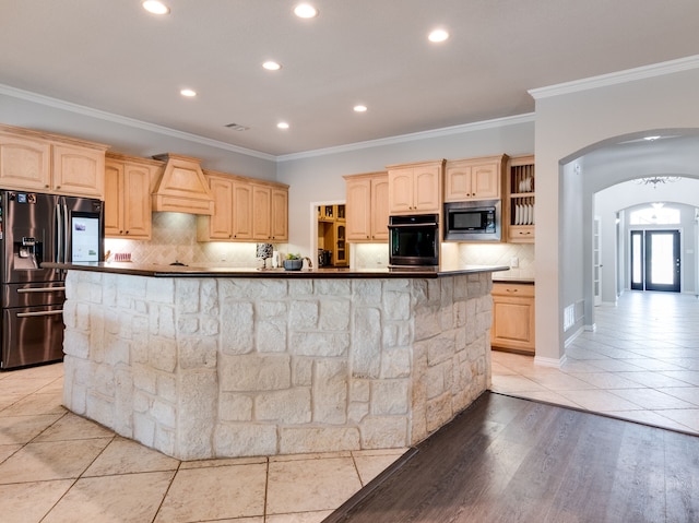 kitchen featuring stainless steel appliances, a center island, and light brown cabinets