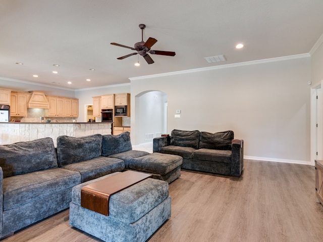 living room with light wood-type flooring, crown molding, and ceiling fan