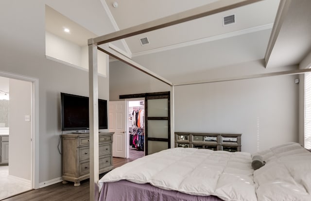 bedroom with lofted ceiling, a closet, dark hardwood / wood-style floors, a spacious closet, and ensuite bathroom