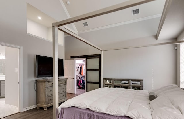 bedroom with a walk in closet, dark wood finished floors, a closet, visible vents, and a high ceiling