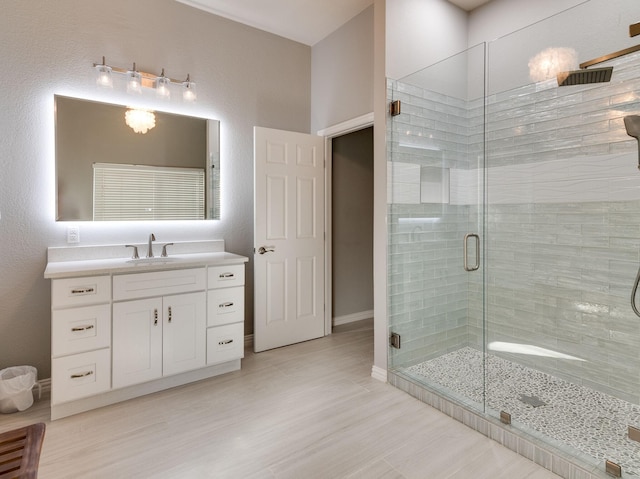 bathroom featuring a stall shower, baseboards, wood finished floors, and vanity