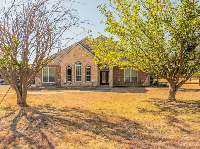 view of front of house featuring a front yard and brick siding