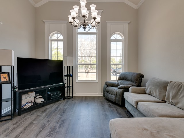 living room with crown molding, vaulted ceiling, hardwood / wood-style floors, and a notable chandelier