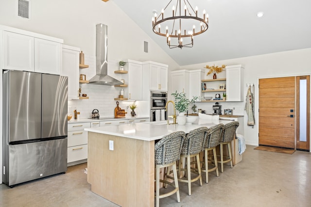 kitchen featuring a kitchen island with sink, island exhaust hood, high vaulted ceiling, stainless steel appliances, and white cabinets