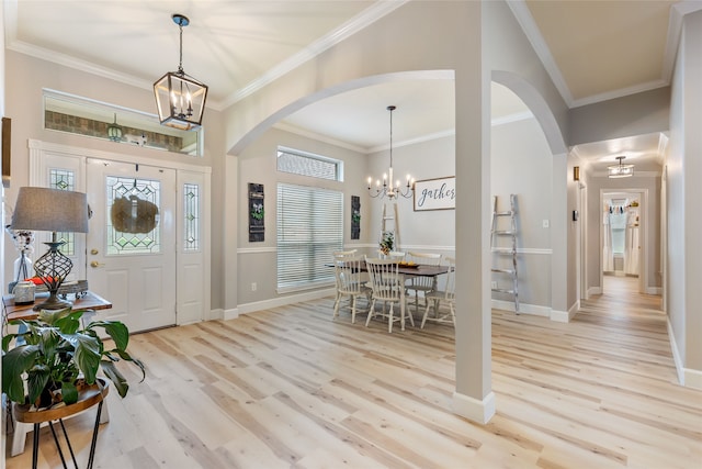 entrance foyer with an inviting chandelier, light hardwood / wood-style flooring, and crown molding