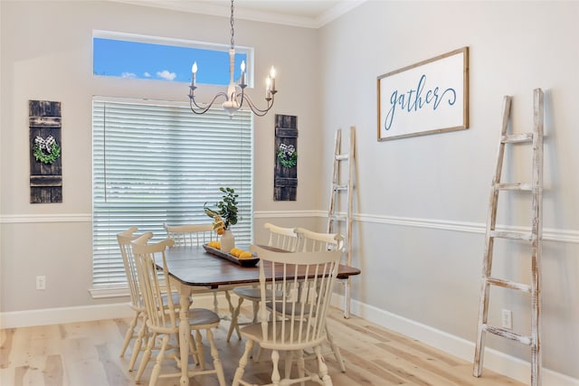 dining space featuring light wood-type flooring, a chandelier, and ornamental molding