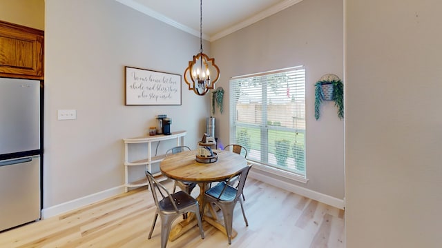 dining room with light hardwood / wood-style flooring, a wealth of natural light, a notable chandelier, and ornamental molding