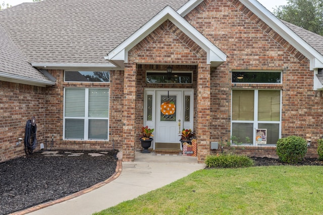 doorway to property with a lawn