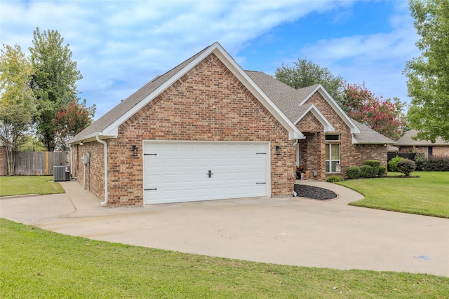 view of front of property featuring a front yard, central air condition unit, and a garage