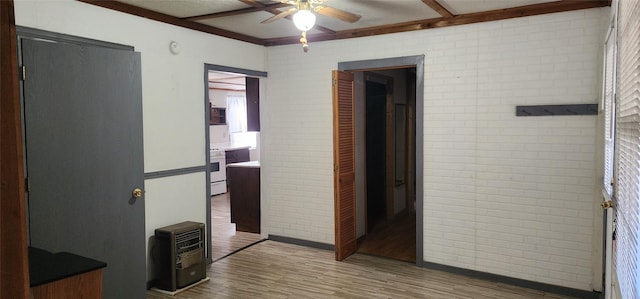 corridor featuring wood-type flooring and brick wall