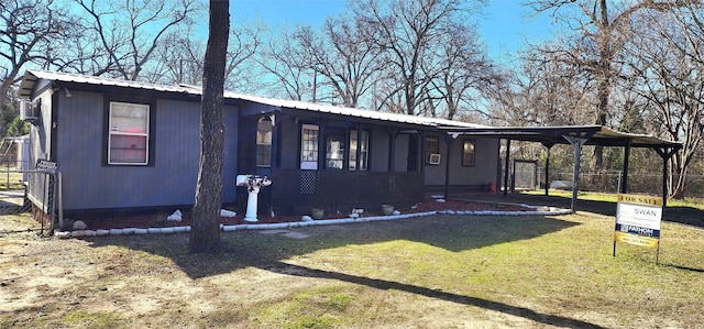 view of front of property featuring a front lawn and a carport