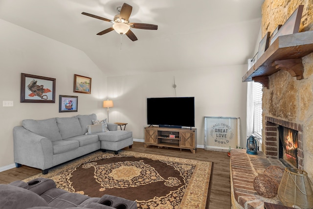 living room featuring lofted ceiling, ceiling fan, a large fireplace, and dark hardwood / wood-style flooring