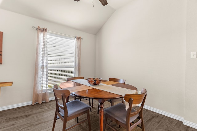 dining area featuring dark wood-type flooring, plenty of natural light, and vaulted ceiling