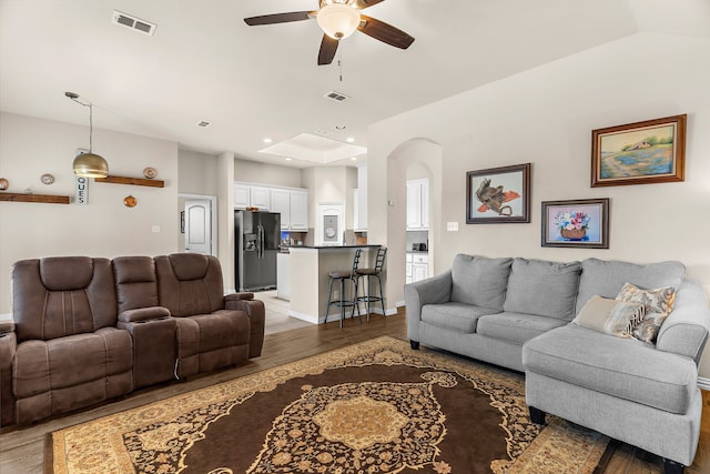 living room featuring lofted ceiling, light hardwood / wood-style flooring, and ceiling fan