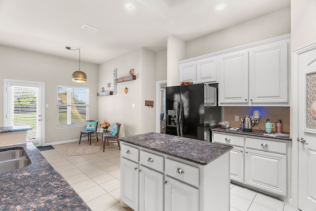 kitchen with white cabinets, light tile patterned floors, backsplash, and black fridge with ice dispenser