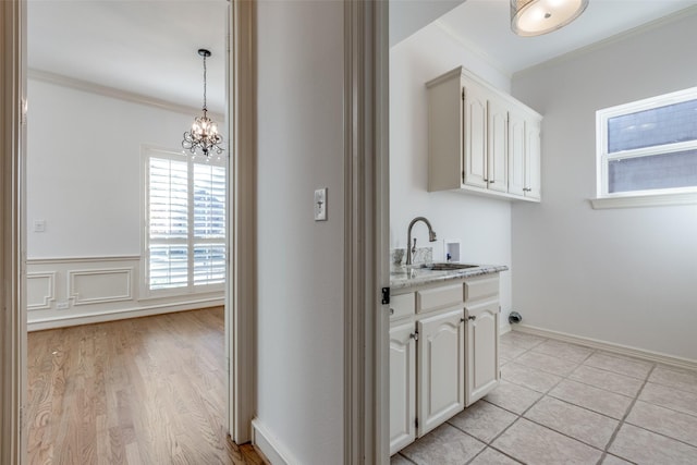 kitchen featuring crown molding, decorative light fixtures, and white cabinets