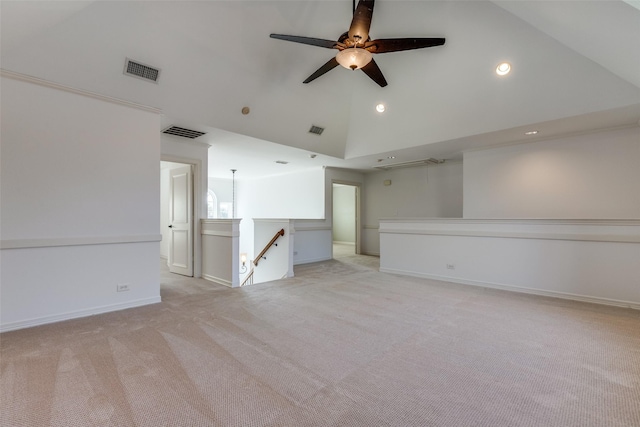 carpeted empty room with ceiling fan and high vaulted ceiling