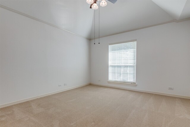 unfurnished room featuring vaulted ceiling, light carpet, and crown molding