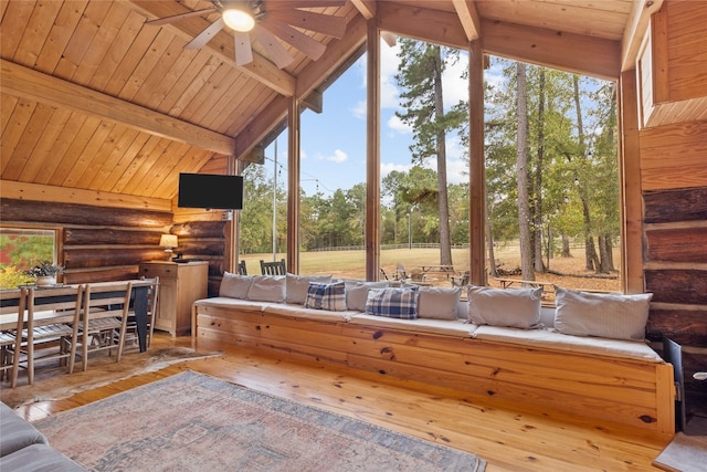 sunroom with vaulted ceiling with beams, ceiling fan, and wooden ceiling